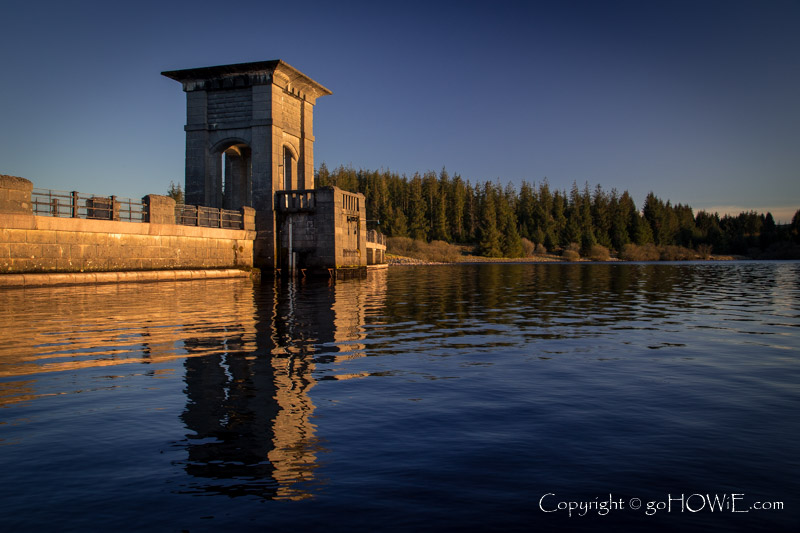 Dam, reflecting in the waters of Alwen Reservoir, North Wales