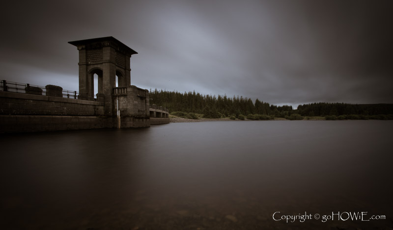 Dam at Alwen Reservoir under cloudy skies at dusk, North Wales