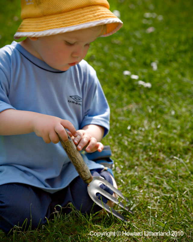 Young boy with trowel in garden