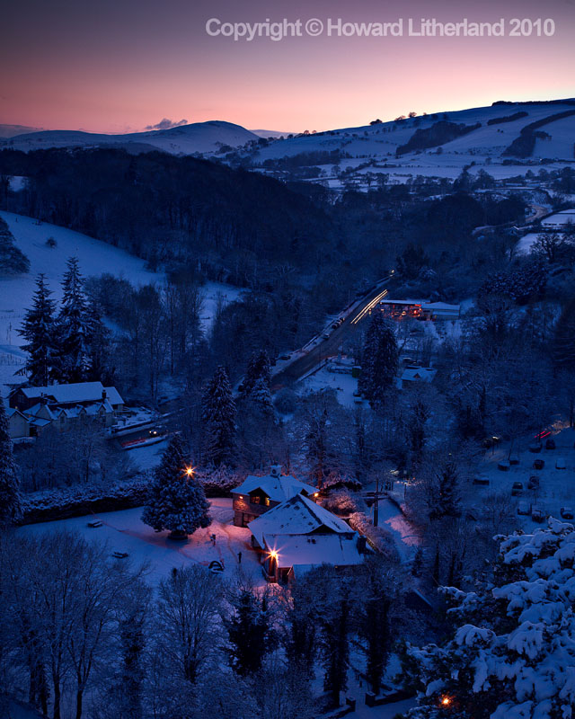 Lit buildings in snow at night, Loggerheads, North Wales