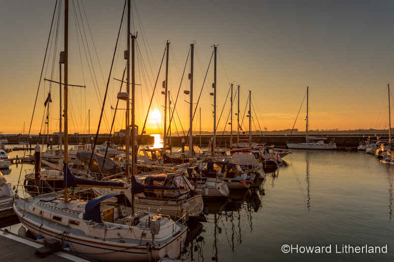 Yachts moored in the Victoria Dock at Caernarfon at sunset on the North Wales coast