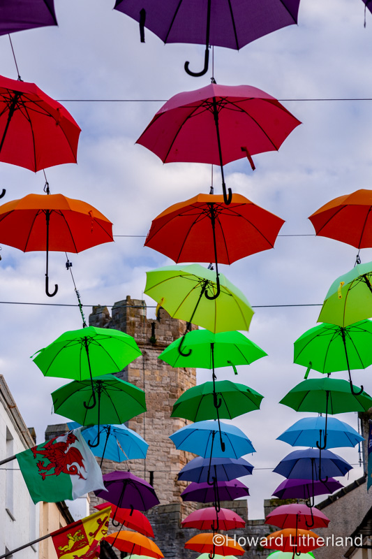 Multi-coloured umbrellas over Palace Street, Caernarfon, North Wales