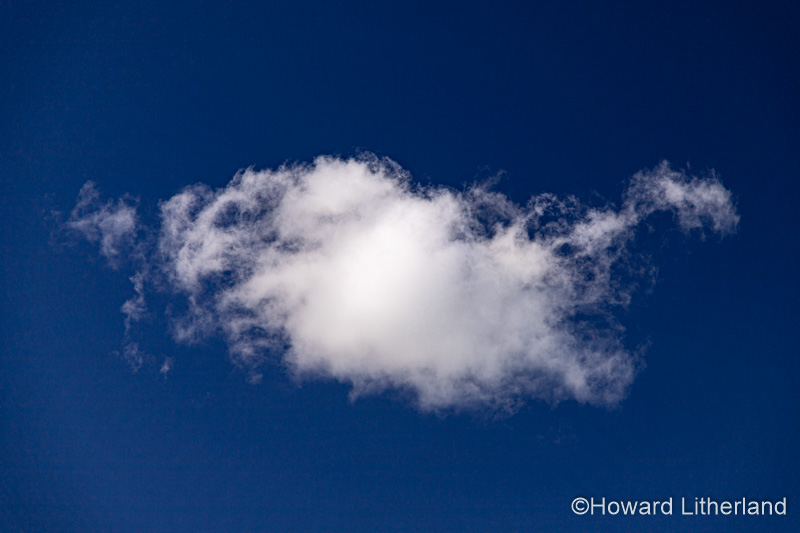 Small cumulus cloud in a deep blue sky