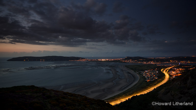 The A55 expressway, the Great Orme and the Conwy estuary at dusk on the North Wales coast, as viewed from the Sychnant Pass