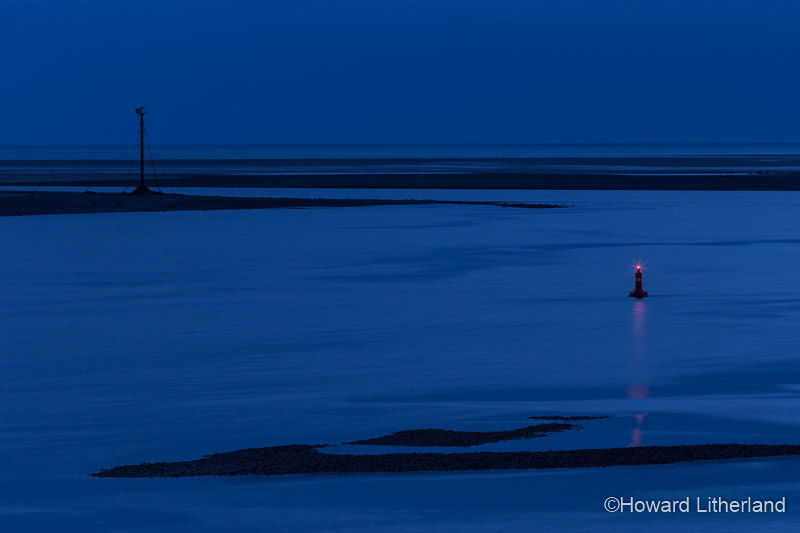 Marker buoy in the Conwy estuary at night at low tide on the North Wales coast