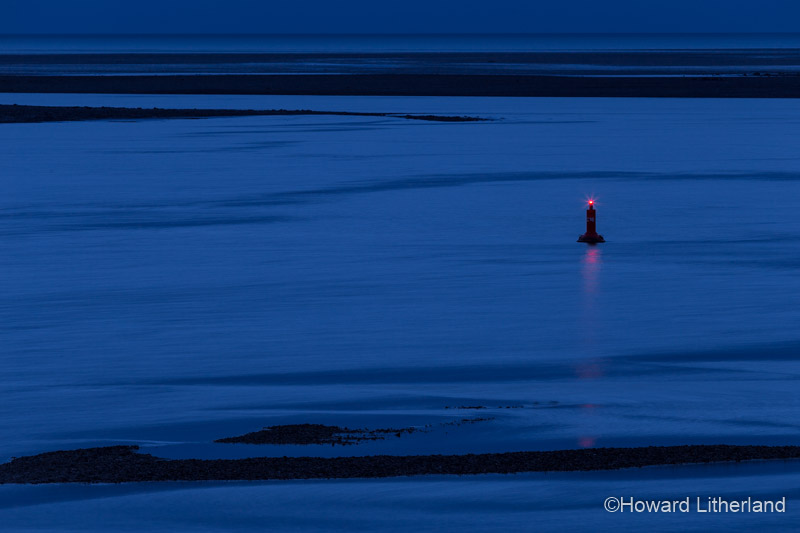 Marker buoy in the Conwy estuary at night at low tide on the North Wales coast