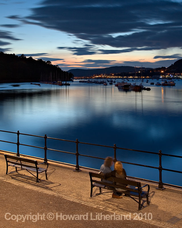 Couple sitting on the dock at Conway at night, North Wales