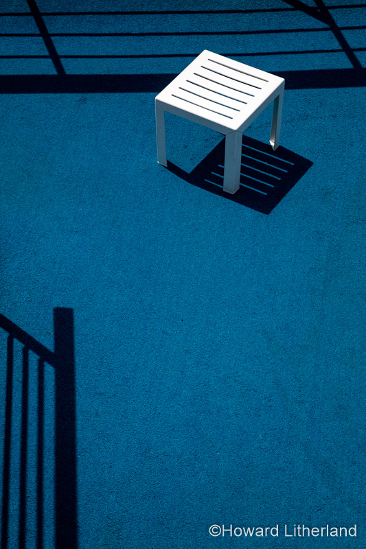 Table with shadows on the deck of a cruise ship