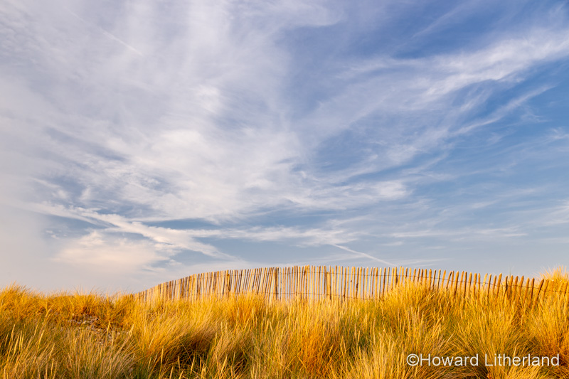 Grass covered sand dune with fence at Llandudno on the North Wales coast