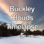Time lapse of cloud formations over snowy woodland at sunset