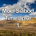 Time lapse video showing cumulus clouds, sunlight and shadow, passing over the snow dusted peak of Moel Siabod, a mountain in the Snowdonia National Park, North Wales