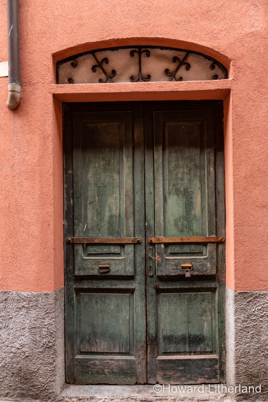 Old, weatherbeaten door at Domaso on the shore of Lake Como in northern Italy