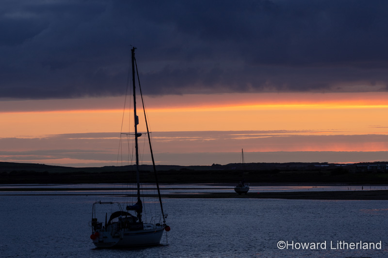 Yacht in silhouette at Ravenglass, Lake District, England