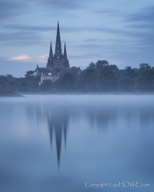 Lichfield cathedral, and its reflection, at dawn, though mist over Stowe Pool, Staffordshire