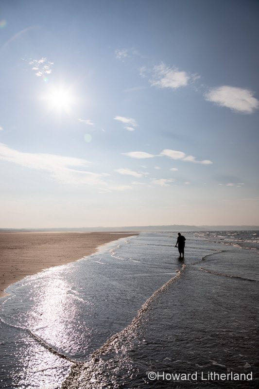 Woman paddling at Llanddona Beach, Anglesey, North Wales