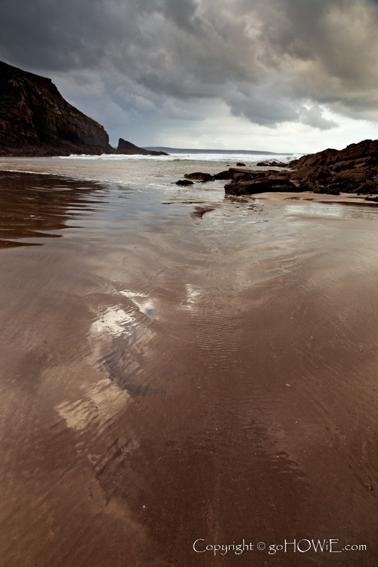 Clouds reflecting in the wet sand at Nolton Haven beach, Pembrokshire National Park, Wales