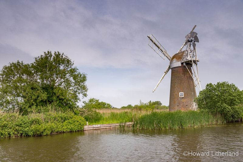 Windmill by a river in the Norfolk Broads, England
