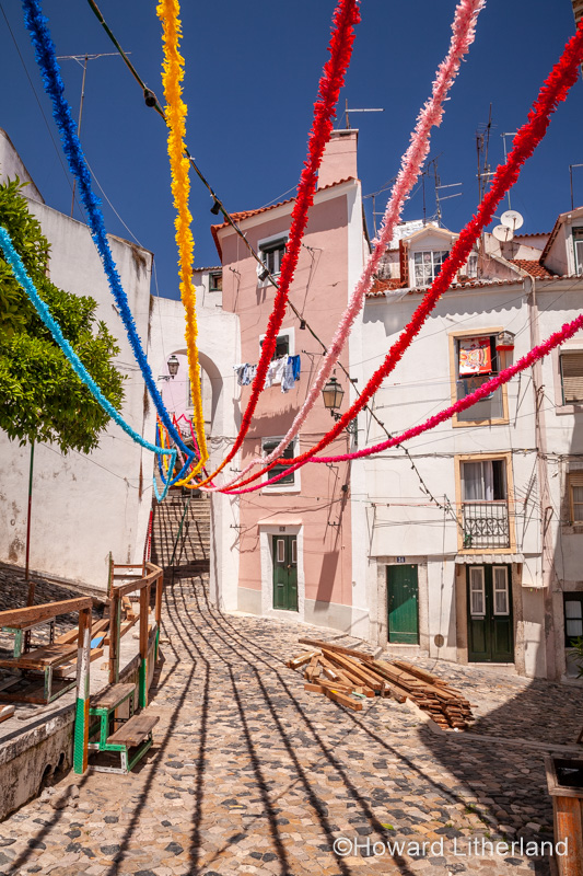 Multicoloured streamers over a narrow street, Lisbon, Portugal
