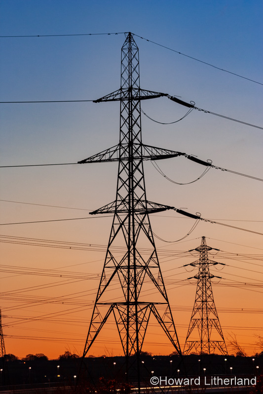 Electricity pylon in silhouette at dusk