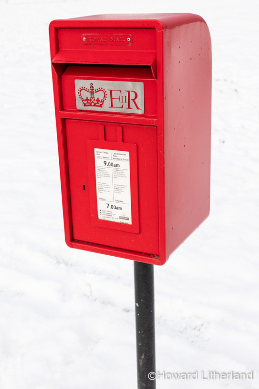 Red Royal Mail postbox in the snow