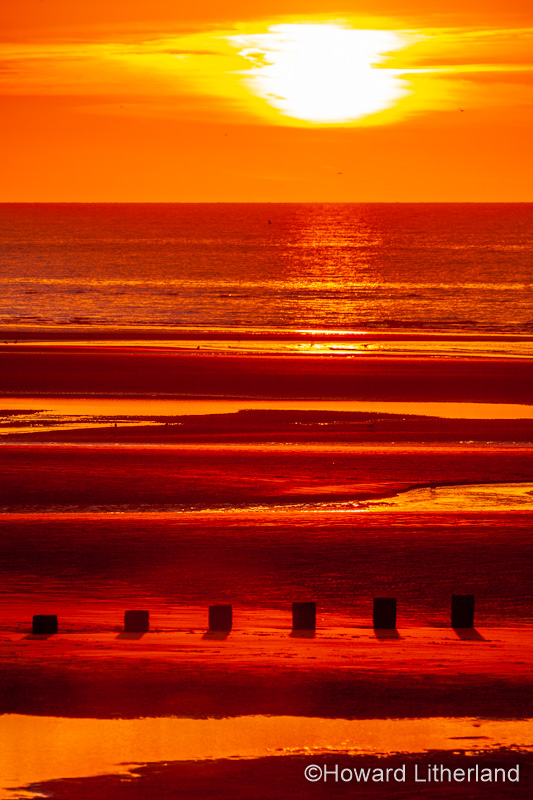 Sunset over Rhyl beach at low tide on the North Wales coast