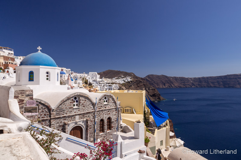 Church with blue dome overlooking the Aegean sea at Oia on the island of Santorini