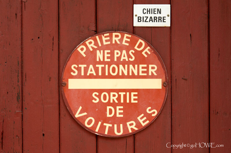 A No Parking and Mad Dog sign in French at Pont de L'Arche, Normandy, France