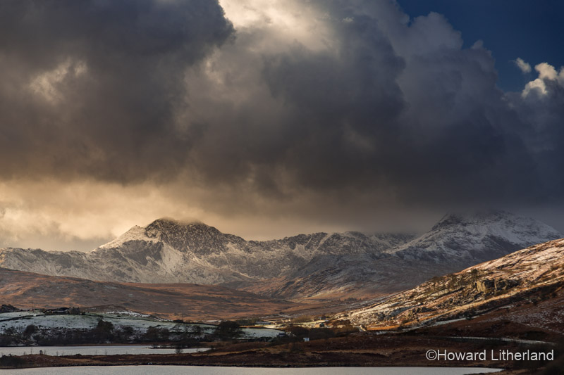 Snow capped Snowdon Horseshoe mountain range under stormy skies in the Snowdonia National Park, North Wales