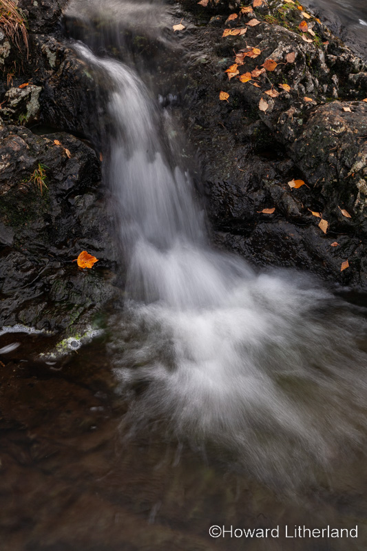 Small waterfall with colouful autumnal leaves