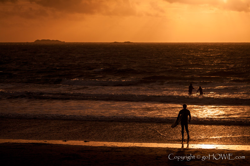 Surfer in silhouette on the beach at Whitesands Bay on the Pembrokeshire coast, Wales